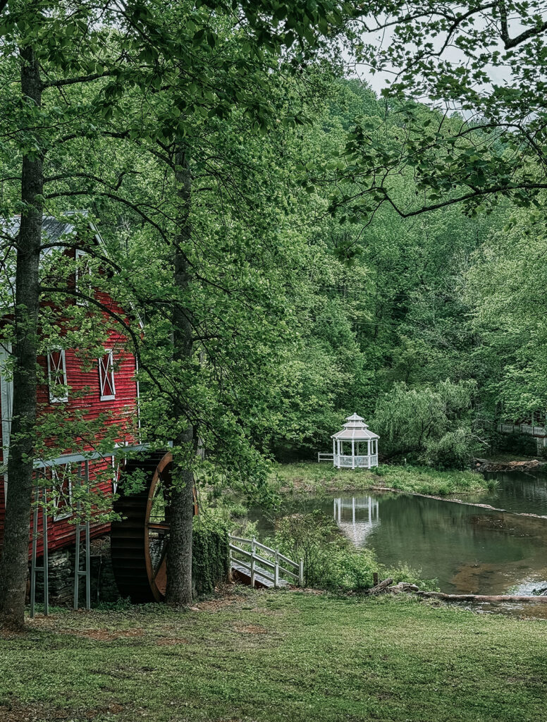 Greenville North Carolina wedding venue ceremony with waterfront views, wooded weddings, bridge, arbor and green landscape.