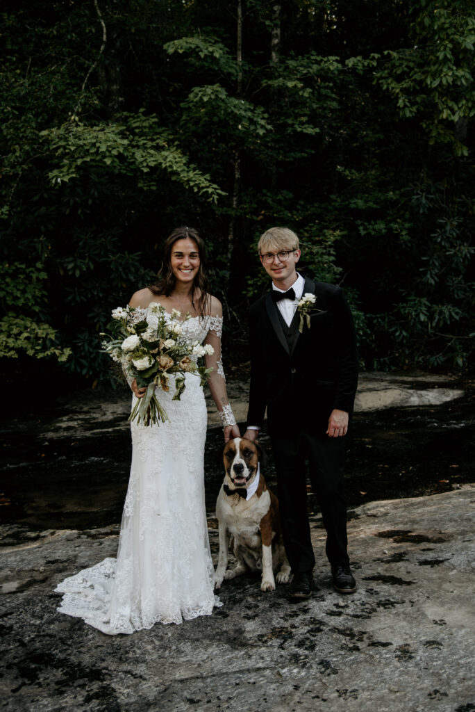  A bride and groom pose for photos with their dog at a pet friendly upstate South Carolina wedding venue