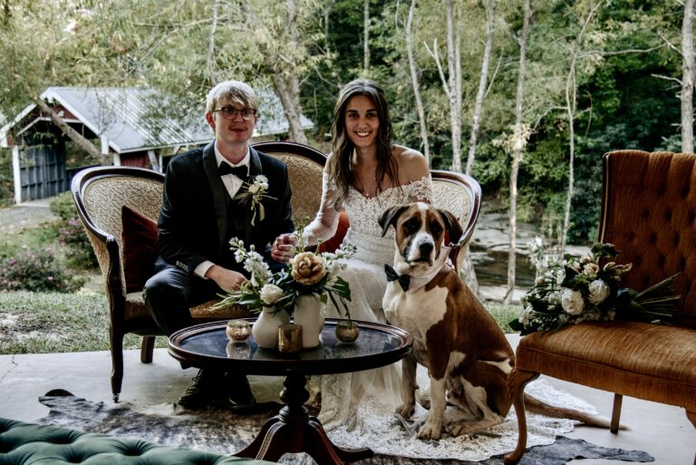 A couple poses for a wedding photo with their dog pet friendly venue in Greenville South Carolina