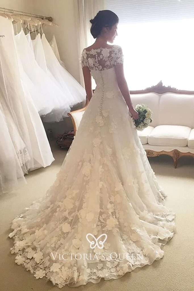 An ivory wedding gown with 3-D floral embellishment 2025 trending wedding gown styles
