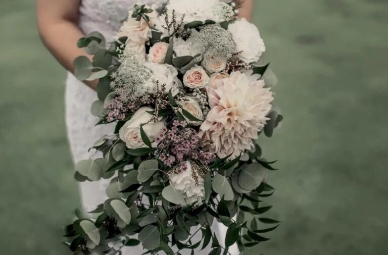 A bride holds a bouquet of natural florals from Inn Season