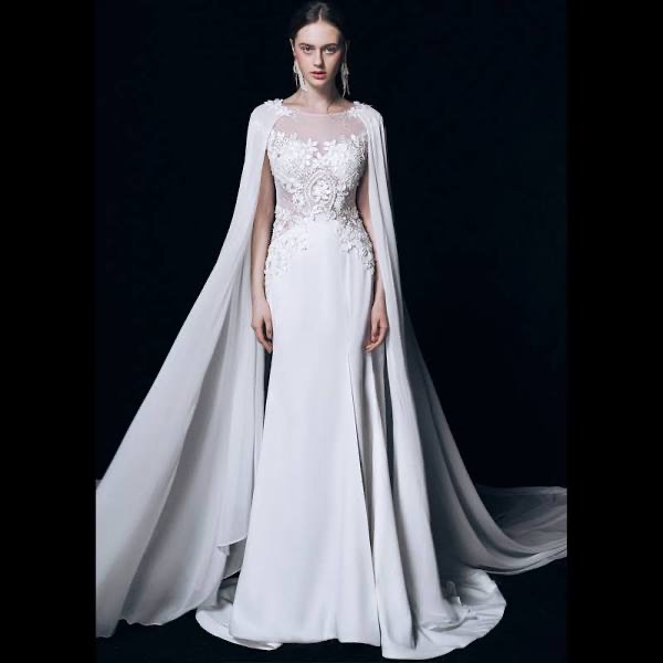 A bride wearing a wedding gown with a layered cape 2025 wedding gown trends