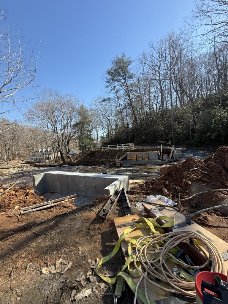 Completed concrete footings sit on either side of the middle tiger river in Landrum South Carolina where construction workers are building a new covered bridge