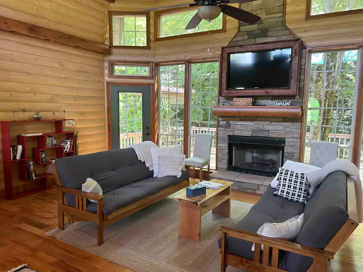 Floor to ceiling windows provide plenty of natural lighting in this cozy log cabin