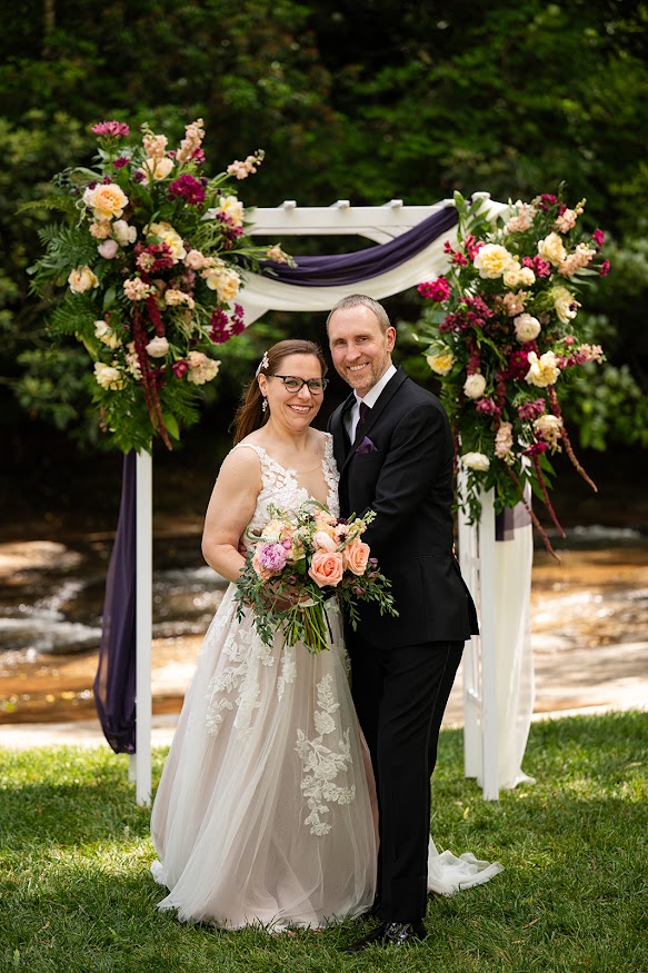 Bride and groom pose for wedding photos by the river and outdoor, garden wedding ceremony at this Greenville SC wedding venue