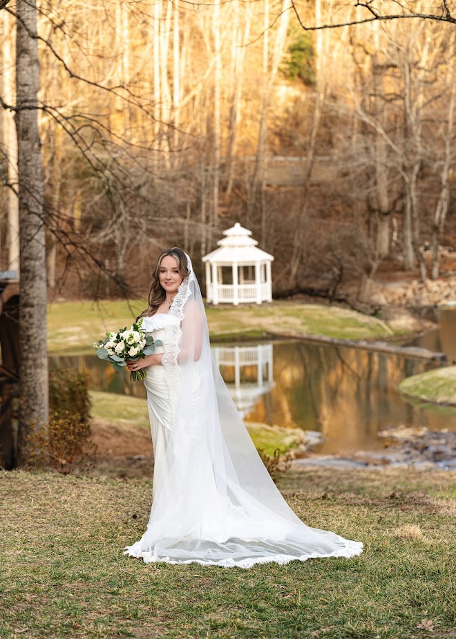 Our beautiful bride poses for wedding day photos by the river at our garden wedding venue near Greenville SC
