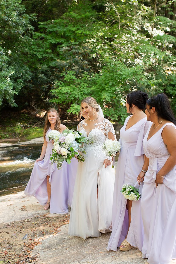 Our beautiful bride & bridesmaids pose for wedding day photos at a spring wedding with fresh flowers and soft pastel color palette.